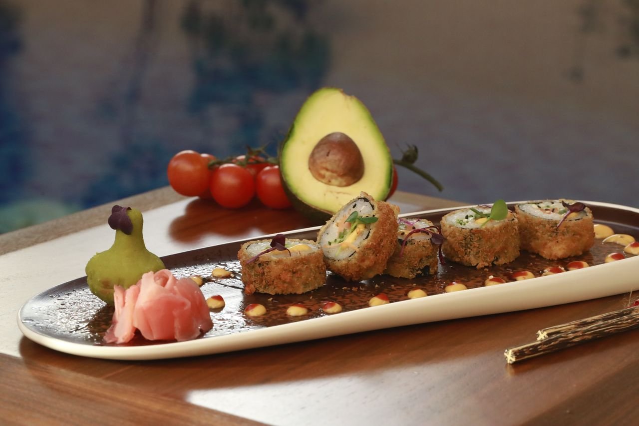 Indulge in mouth-watering crispy sushi rolls featuring avocado and pickled ginger.
