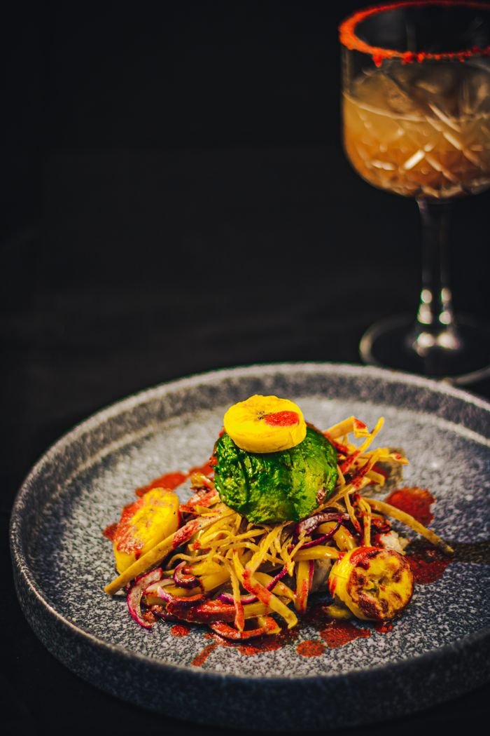 A vibrant Mexican dish served on a stone plate with an exotic drink, capturing rich culinary tradition.